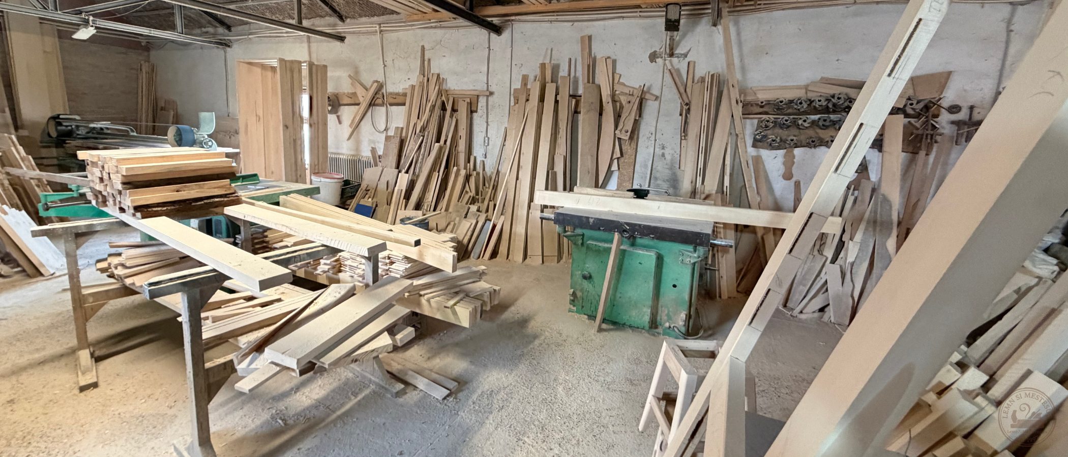 Atelierul de prelucrare lemn masiv cu mașini industriale și materiale în lucru