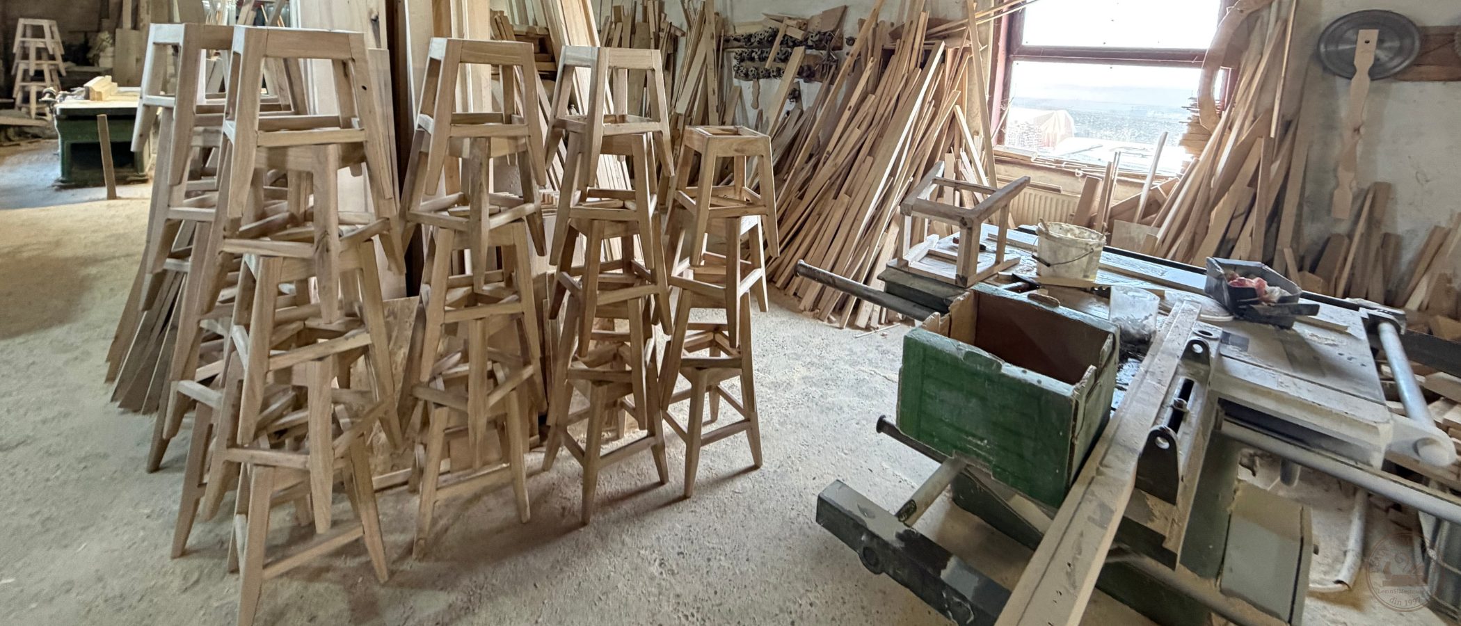 Producție în serie de scaune din lemn masiv, zeci de piese stivuite în atelier