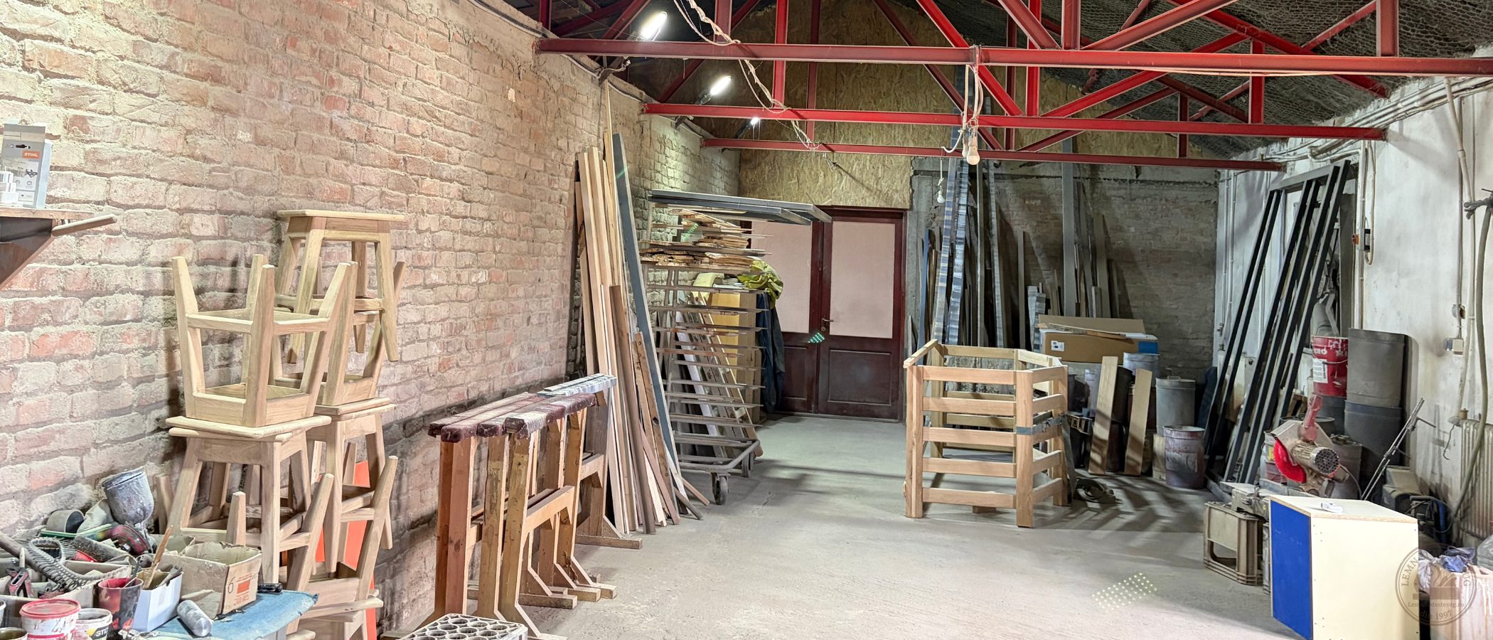 Zonă de asamblare în atelier, cadre de scaune din lemn masiv pe banc de lucru